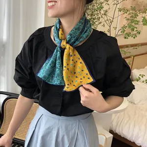Elegante sciarpa in seta bifacciale con un esclusivo design stampato blu e giallo.