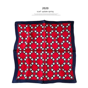 Gedetailleerd overzicht van een luxe rode zijden vierkante sjaal met geometrisch patroon.