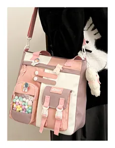 Détail du sac bandoulière en toile kawaii, blocs de couleurs rose et blanc, jolies épingles.