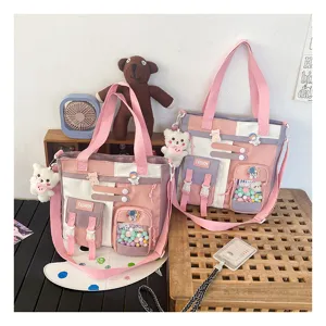 Vue détaillée du sac cabas en toile bicolore rose avec plusieurs poches et jolis charms.
