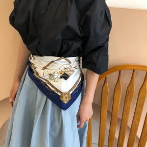 Silk square scarf worn as a waist accessory featuring vintage carriage and chain print.