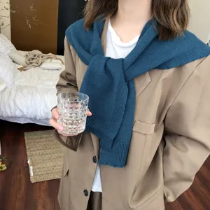 Nahaufnahme eines dunkelblauen Strickschals als Schulterüberwurf über einem schicken Blazer.
