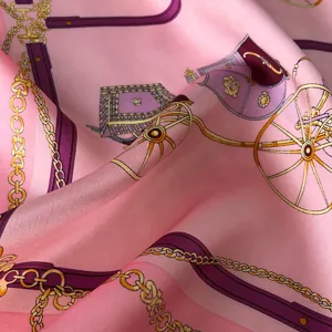 Elegant pink silk scarf with luxury carriage and chain print, soft satin fabric detail.
