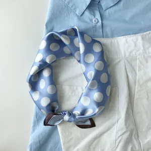 Detailaufnahme eines blauen Seidentuchs mit Punkten, elegantes Halstuch stilvoll arrangiert.