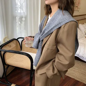 Elegantes einfarbiges Strickschal-Schultertuch und brauner Blazer Detailansicht im Herbst.