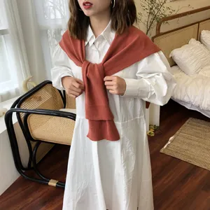 Weisses langaermeliges Hemd kombiniert mit einem rostroten Strickschal, elegant und gemuetlich.