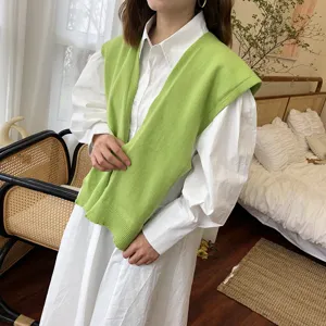 Detailansicht eines grünen Strickschals als Überwurf kombiniert mit Hemd für den Herbst.