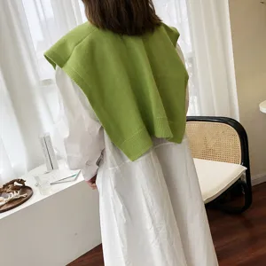 Grünes Strickschultertuch kombiniert mit weißem Hemd, modisches Detail für den Herbst.