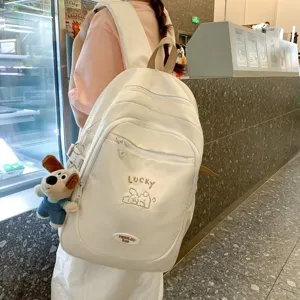 Detailed lifestyle view of a cute white college style backpack worn by a student outdoors.
