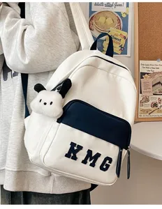 Vista detallada de mochila blanca bonita con colgante de peluche y bolsillo azul.