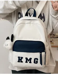 Vista detallada de mochila escolar infantil con colgante de cachorro lindo y letras elegantes.