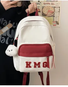 Mochila escolar para niños, diseño blanco y rojo con colgante de peluche para uso diario.