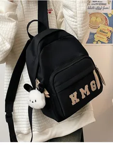 Mochila escolar negra para niños con lindo colgante de peluche, ligera y cómoda de usar.