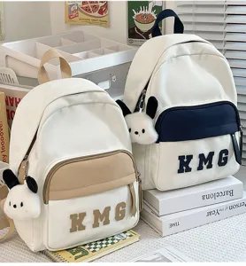 Bonita mochila escolar para niños con bolsillo frontal y llavero de perrito de peluche para viajes.
