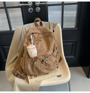 Detailed view of the casual nylon backpack in brown, showcasing functional pockets and design.