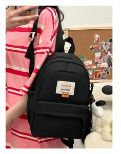 Zaino mini nero da donna, piccolo zainetto casual carino con tasche e ciondolo elegante.