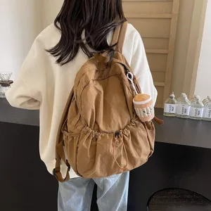 Casual brown nylon backpack for women, large capacity travel school bag with cute pendant.