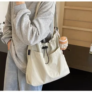 Casual minimalist shoulder tote bag detail view with drawstring pocket and cute plush charm
