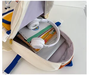 Vista dettagliata dell'ampio scomparto interno dello zaino scolastico colorato con libri.