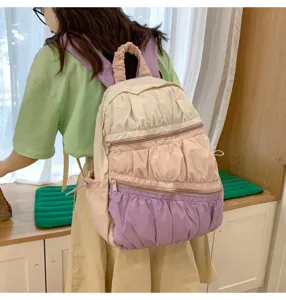 Dettaglio dello zaino con pieghe in stile torta colorata, volant e comode tasche pratiche.
