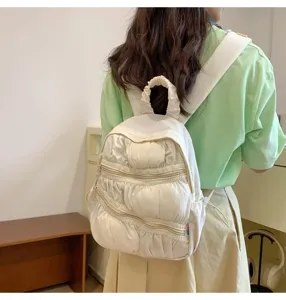 Dettaglio mini zaino plissettato bianco con tasche multiple e simpatico design soffice.