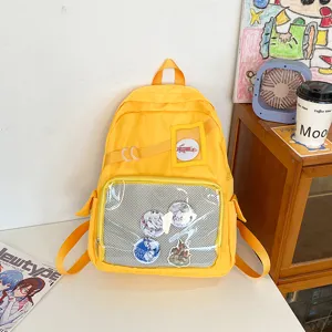 Gele transparante itabag rugzak met voorvak en schattige anime badges voor scholieren.