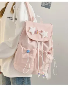 Cute pink backpack detail with plush stars, white drawstrings and shoulder straps for daily use.