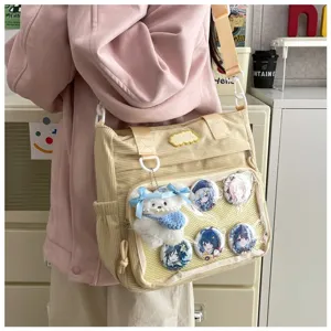 Corduroy ita tas detailshot met doorzichtig voorvak, anime badges en schattige pluche berenhanger.