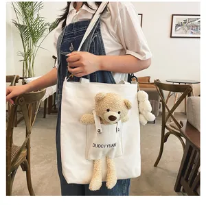 Vista detallada del bolso cruzado de lona de peluche con osito para estudiantes y mujeres.