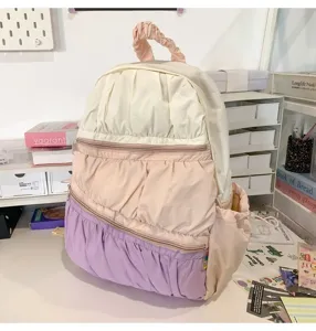 Dettaglio zaino plissettato con design a balze multistrato e colori pastello delicati.