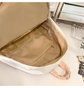 Vista dettagliata dello zaino casual, beige chiaro con grazioso manico arricciato rosa.