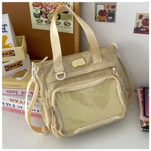 Corduroy ita tas detail met doorzichtig voorvak, beige stof en comfortabele riemen.