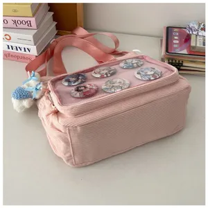 Roze corduroy ita tas detail met doorzichtig mesh venster, anime badges en schattige pluche hanger.