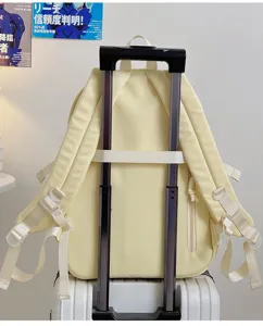 Detailed view of a pastel yellow casual backpack with luggage strap and side zipper pocket.