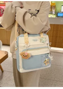 Vue détaillée du sac bandoulière en toile bicolore avec joli pendentif en peluche d'ours.