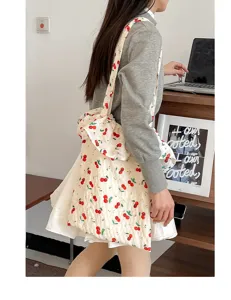 Detailaufnahme der beigen Mesh-Umhängetasche mit Kirschprint und eleganten Rüschen.