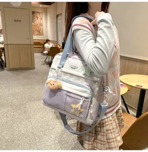 Vue detaillee du grand sac bandouliere en toile pour filles etudiantes avec de jolies pendeloques.