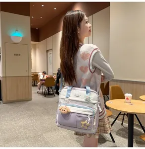 Sac à bandoulière en toile pour étudiants grande capacité fourre-tout avec pendentif peluche.