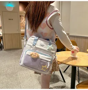Sac d'école décontracté pour filles, grand sac bandoulière de grande capacité avec pendentifs.