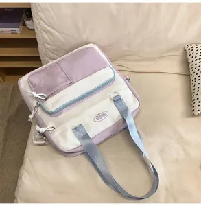 Sac à bandoulière violet et blanc multi-poches pour étudiantes et usage quotidien à l'école.