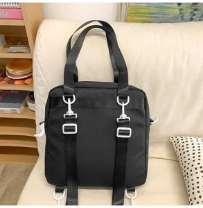 Vue détaillée du sac à dos d'étudiant noir polyvalent avec des boucles blanches.