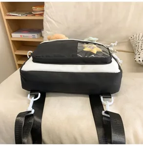 Détails du sac d'école noir et blanc avec poche transparente et sangles réglables.