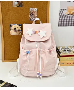 Pink cute school backpack detail view featuring plush star charms, colorful beads, and durable nylon fabric.