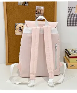 Pink casual backpack detail view showing white shoulder straps, zipper pocket and clean stitching.