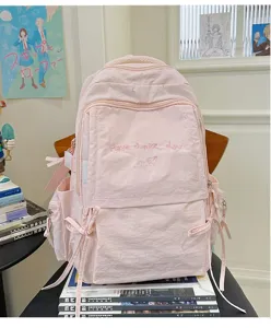 Roze studentenrugzak detail met borduurwerk en strikken aan de zijkant voor dagelijks gebruik.