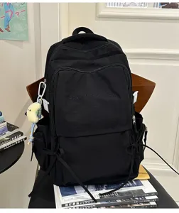 Gedetailleerd overzicht van zwarte canvas rugzak met borduurwerk en ruime zakken.