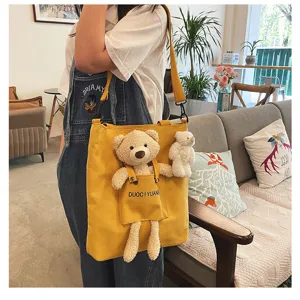 Vista detallada de la bonita bolsa de lona amarilla con muñeco de peluche y diseño.