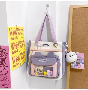 Detalle de bolso de lona, bolso cruzado con bolsillo transparente y bonitos colgantes.
