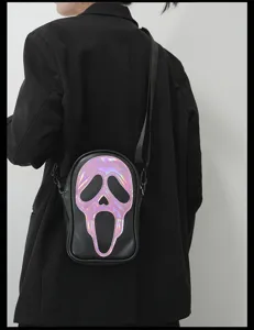 Vue détaillée du sac bandoulière noir avec motif de visage de fantôme holographique et sangle.