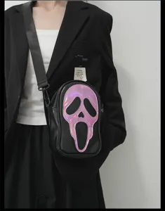 Gros plan sur le sac bandoulière noir avec un visage de fantôme laser brillant et sangle.